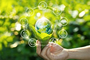 An image depicting sustainability and environmental conservation, with a hand gently holding green leaves adorned with a water droplet surrounded by icons.