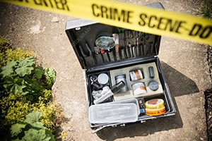 An image of a crime scene with a briefcase containing forensic tools.