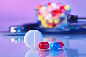 A close-up of pill capsules in various colors, representing different types of pharmaceutical drugs.